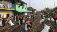 Tim KAI Daop 8 Surabaya bersama dengan warg sekitar sedang melakukan bersih-bersih. (ist) - Sterilisasi Jalur KA Malang-Pakisaji, KAI Siapkan Nataru yang Aman
