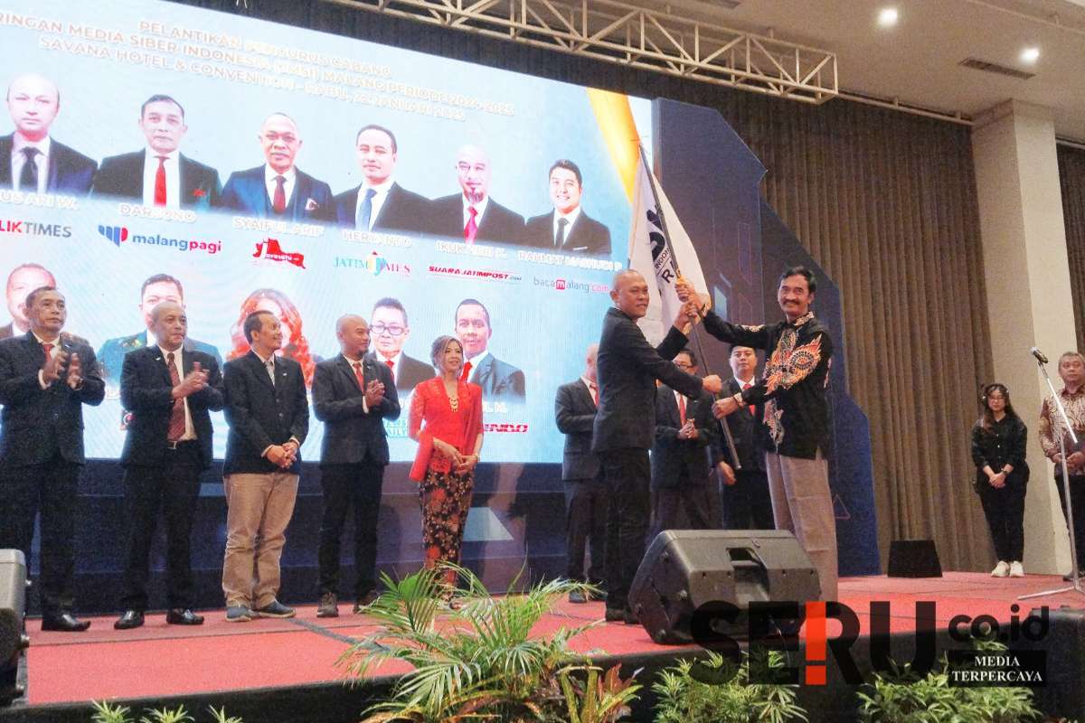 Ketua JMSI Jatim (kanan) memberikan bendera JMSI kepada ketua JMSI Malang Raya (kiri). (Seru.co.id/afi) - Pengurus JMSI Malang Raya Resmi Dilantik, Siap Kawal Kebijakan dan Jaga Independensi Media