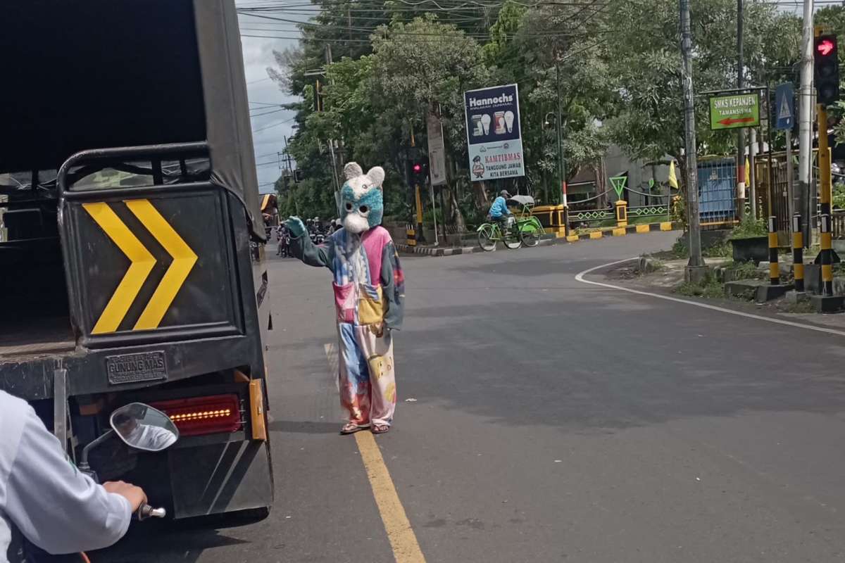Manusia boneka yang tengah mengamen di pertigaan PLN Kepanjen. (ist) - Satpol PP Kabupaten Malang Tertibkan Anjal, Gepeng dan Manusia Boneka Serta Rumah Singgahnya