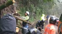 Petugas Rescue gabungan berupaya mengevakuasi material longsor yang menutup jalan. (ist) - Polres Batu Tanggap Cepat Longsor Pujon, Lalulintas Buka Tutup