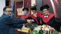 Dr Riyad SH MH saat menyalami Prof Dr Rachmad Syafa’at MSi usai dinyatakan lulus ujian terbuka disertasi. (Seru.co.id/afi) - Mahasiswa Hukum UB Gagas Reformasi Ekowisata Nasional, Usul Badan Terpadu di Bawah Presiden