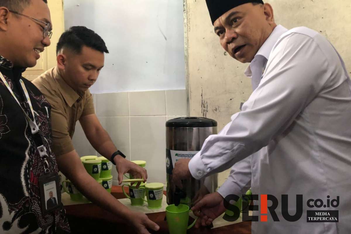 Menkop Budi Arie Setiadi, saat mengambil susu dari dispenser untuk MBG di MTs Annur Bululawang. (wul) - Menkop Budi Arie: Dispenser Susu MBG Bakal Jadi Role Model di Wilayah Lain