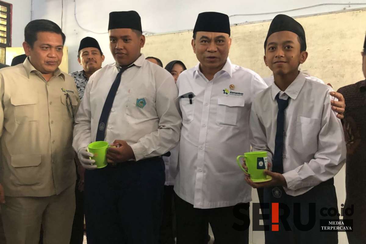Menkop Budi Arie menyerahkan susu dalam gelas kepada siswa MTs Annur Bululawang. (wul) - Menkop Budi Arie: Dispenser Susu MBG Bakal Jadi Role Model di Wilayah Lain