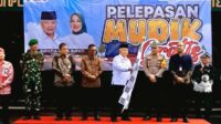 Sanusi tengah mengibarkan bendera berwarna hitam putih tanda pemberangkatan bus-bus program mudik gratis Pemkab Malang. (ist) - Bupati Sanusi Berangkatkan 399 Peserta Mudik Gratis Pemkab Malang ke Lima Daerah Tujuan
