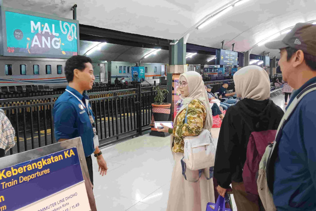 Relawan Komunitas Railfans membantu memberikan pengumuman di Stasiun Malang. (ist)