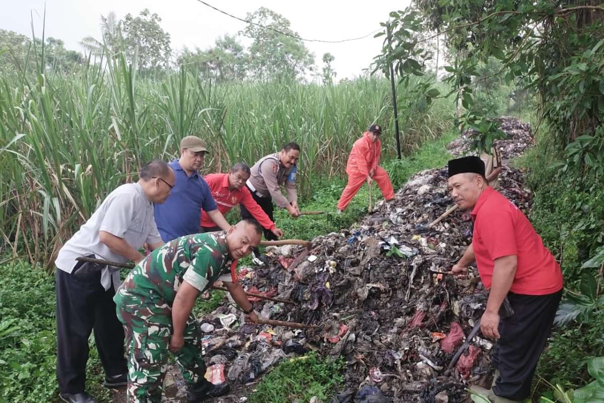Proses pembersihan sampah yang dibuang secara ilegal di Kecamatan Singosari. (ist) - Polisi Selidiki Kasus Pembuangan Sampah Ilegal di Kecamatan Singosari hingga Tutupi Jalan