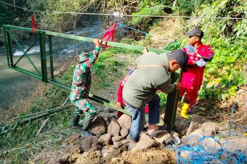 Babinsa Klojen Bantu Warga Pasang Tiang Utama Jembatan Perintis Polehan - Kedungkandang