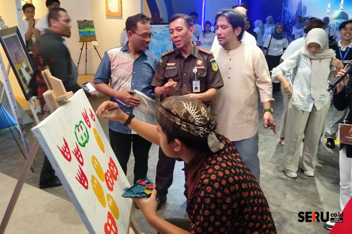 Salah satu anak dengan ASD menyelesaikan lukisan, usai meneruskan goresan Kajari Kota Malang. (rhd)