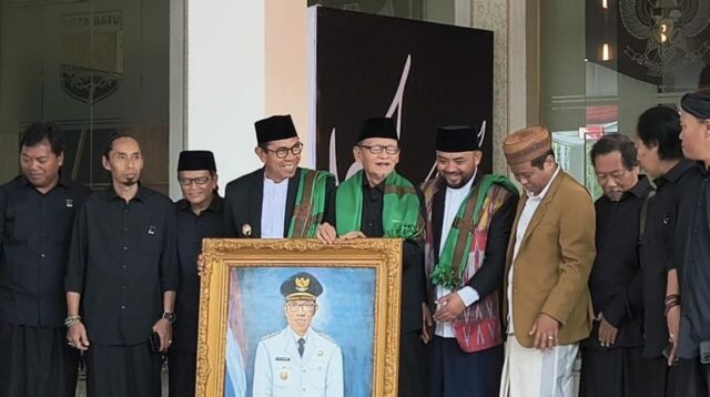 Wali Kota Batu menerima kenang-kenangan berupa lukisan dirinya, karya dari KH D Zawami Imron. (dik) Wali Kota Batu Buka Pameran Seni Kaligrafi Bertajuk The power of Quran Aksara Ilahi