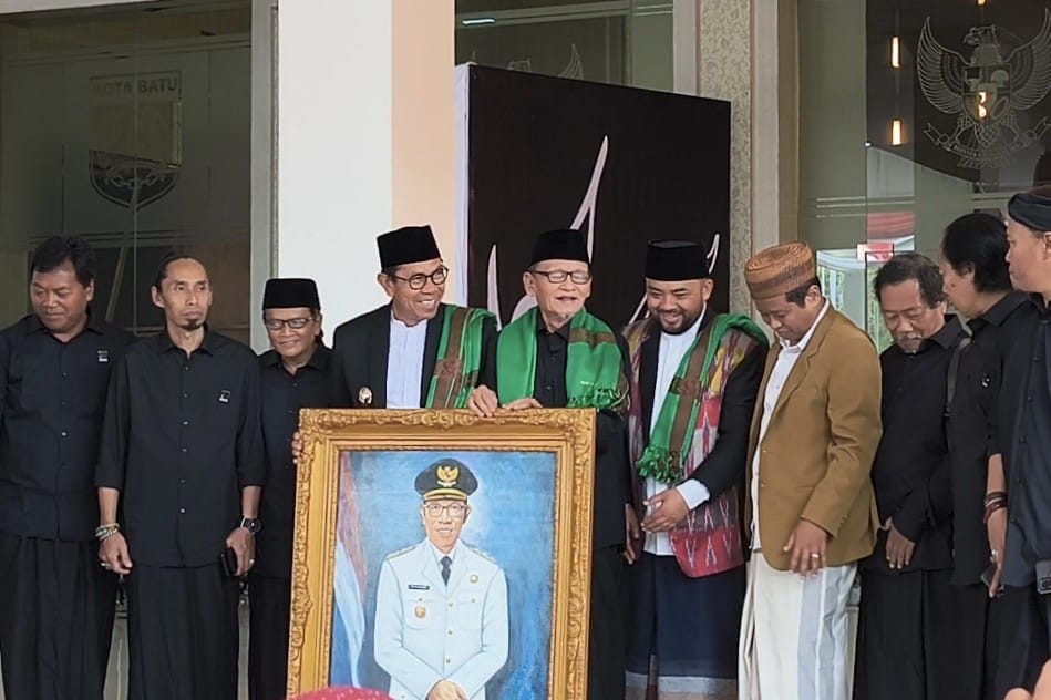 Wali Kota Batu menerima kenang-kenangan berupa lukisan dirinya, karya dari KH D Zawami Imron. (dik) Wali Kota Batu Buka Pameran Seni Kaligrafi Bertajuk The power of Quran Aksara Ilahi