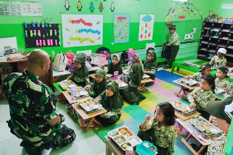 Babinsa Buring dampingi penyaluran program MBG untuk anak sekolah. (ist) Babinsa Buring Dampingi Penyaluran Program MBG untuk Anak Sekolah