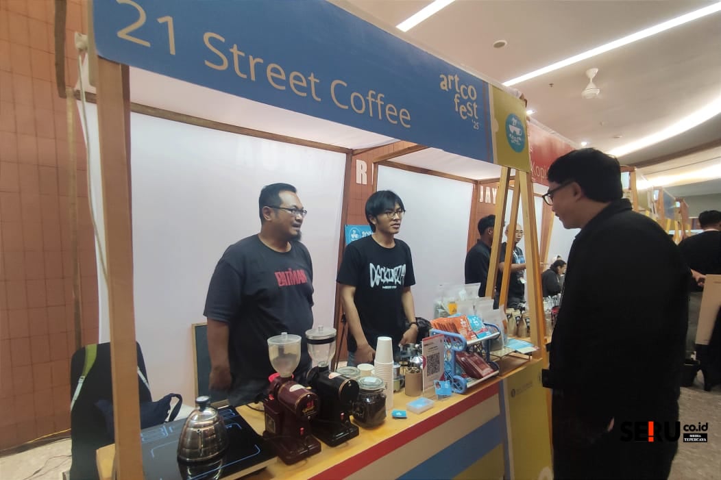Salah satu peserta Artcofest 2025 melayani pembeli saat pameran. (rhd)