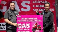 Jimmy Tambunan (kiri) menyerahkan simbolis hadiah motor listrik kepada driver ojol Malang, Nanang. (ist) Driver Ojol Malang Raih Motor Listrik Gebyar Hadiah Smartfren Tahap 3