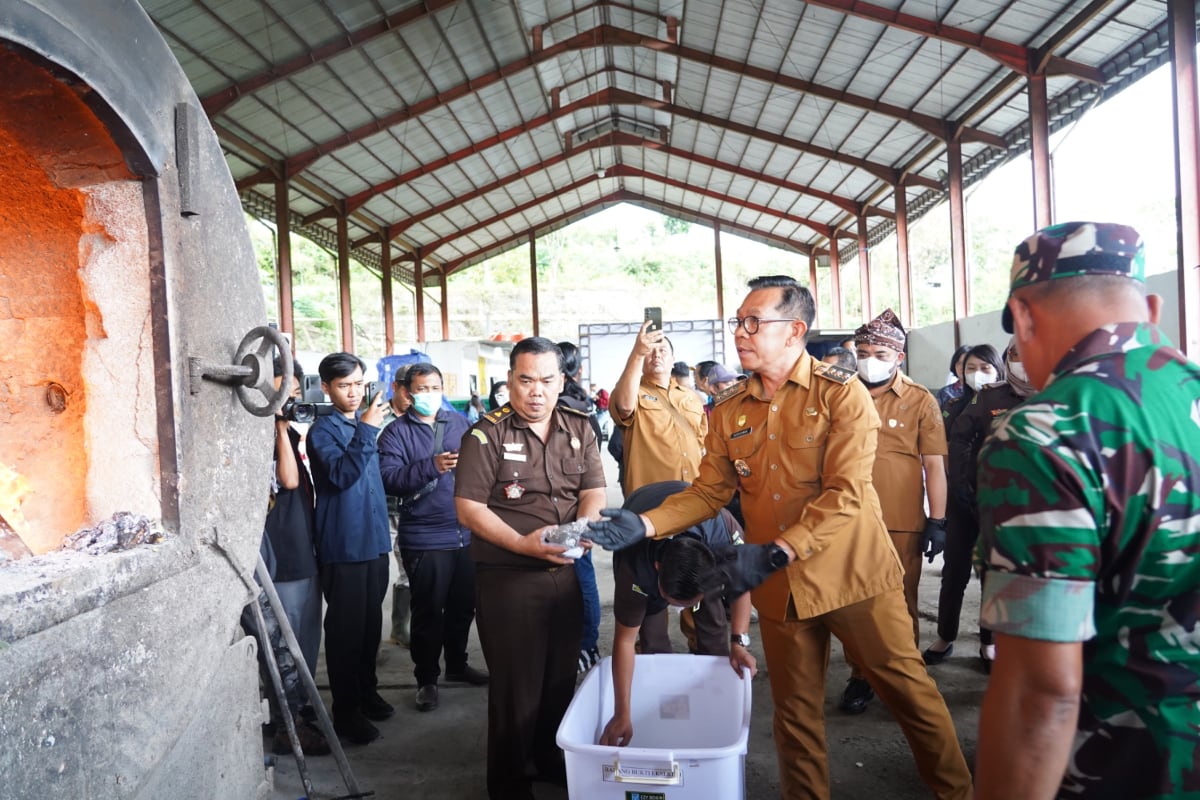 Wali Kota Batu lemparkan sejumlah barang bukti tindak pidana ke dalam mesin incenerator milik DLH Batu untuk dimusnahkan. (ist) Forkopimda Batu Bersama-sama Musnahkan Barang Bukti Puluhan Kasus Pidana Berkekuatan Hukum Tetap