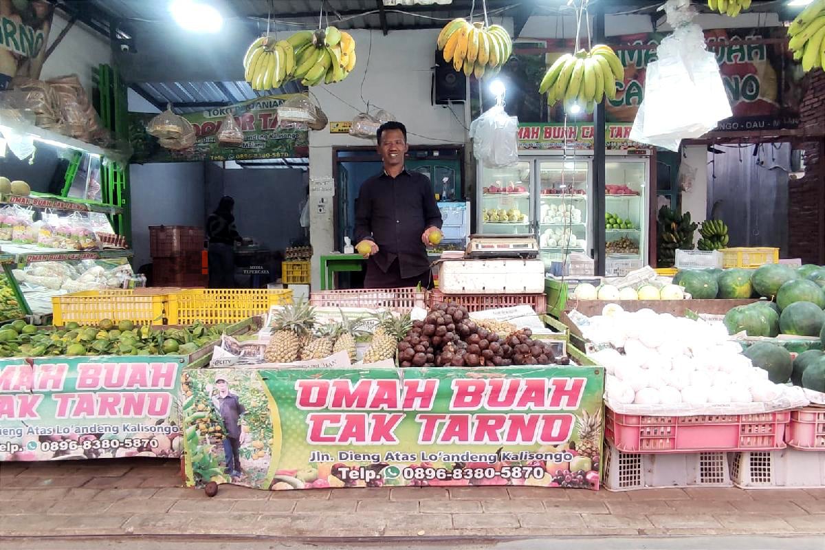 Sutarno menjajakan hasil kebunnya di Omah Buah Cak Tarno. (rhd)