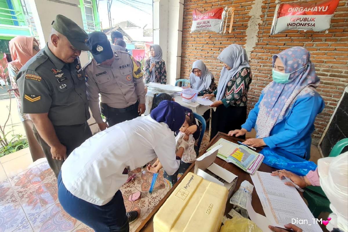 Babinsa Buring dampingi nakes ORI campak anak-anak. (ist) Babinsa Buring Dampingi Nakes ORI Campak Anak-anak