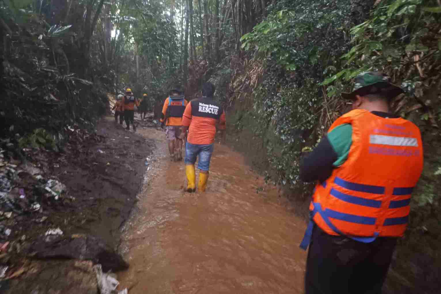 Proses pencarian korban di aliran sungai.(Ist_11zon Remaja di Sumawe Hilang Terbawa Arus Parit Saat Hujan Deras