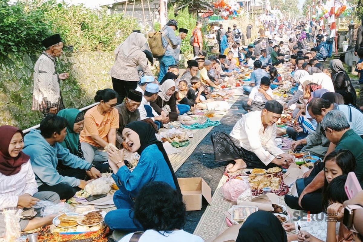 Warga Dusun Mlambong Desa Sruni melaksanakan kenduri dan makan bersama di sepanjang jalan. (gts) Warga Boyolali Arak Ratusan Sapi dan Kambing, Tradisi Unik Bakda Kupat