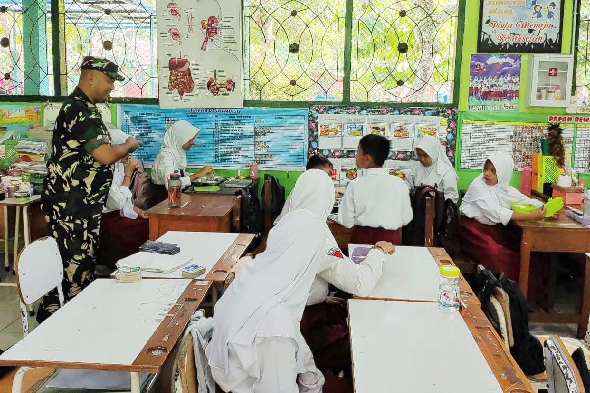 Babinsa Kedungkandang dampingi distribusi MBG di sekolah wilayah Buring. (ist) Babinsa Kedungkandang Dampingi Distribusi MBG di Sekolah Wilayah Buring