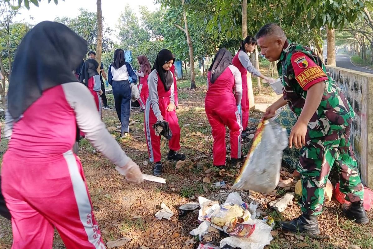Babinsa Pandanwangi kerja bakti bersama warga dan siswa SMPN 24 Kota Malang. (ist) Babinsa Pandanwangi Kerja Bakti Bersama Warga dan Siswa SMPN 24 Kota Malang