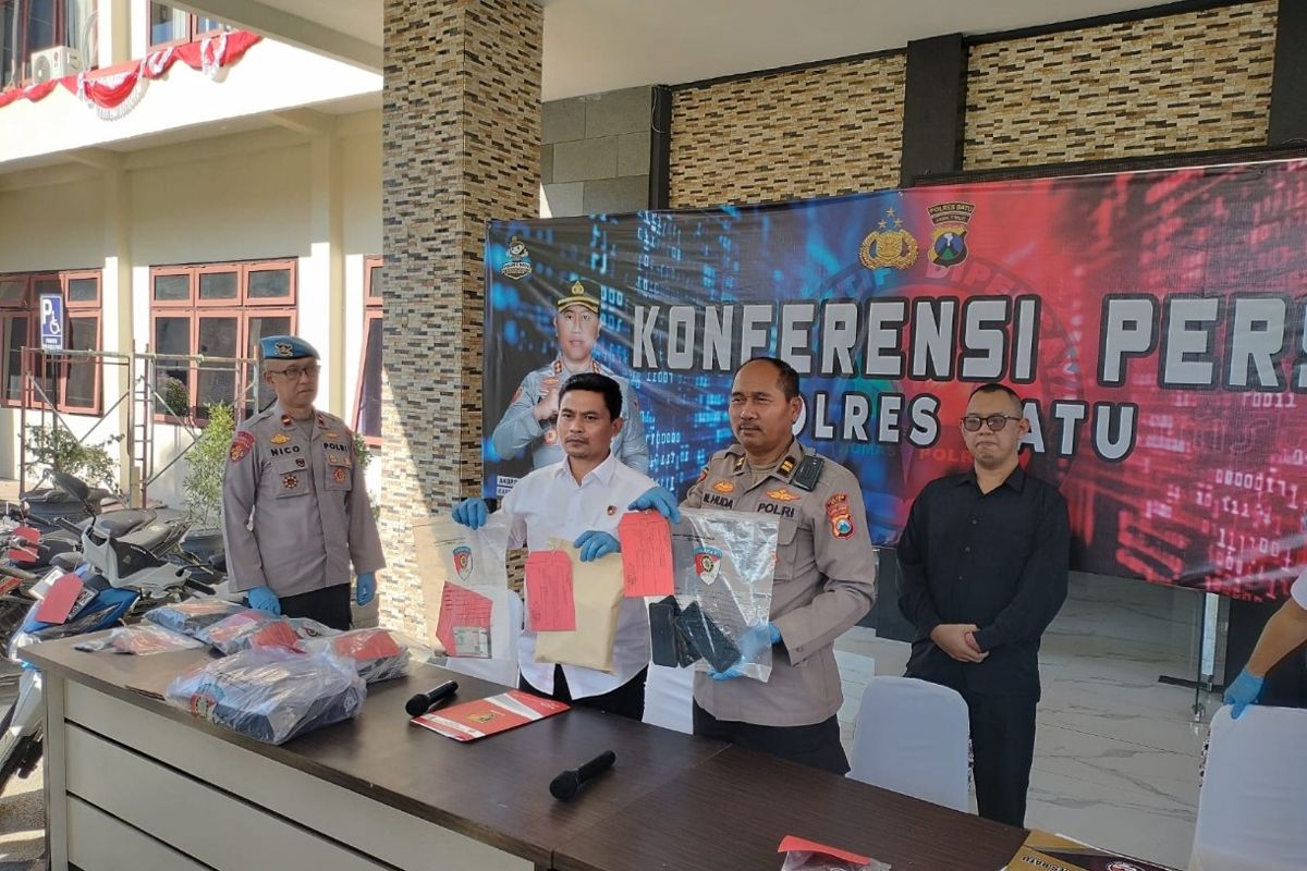 Kasat reskrim Polres Batu (Kemeja Putih) dan PS Kasi Humas Polres Batu (berseragam Polisi) menunjukkan Barang Bukti kejahatan. (dok. Humas Polres Batu). Usai Selidiki Laporan Warga, Tim URC Polres Batu Ringkus Dua Penadah Motor Curian