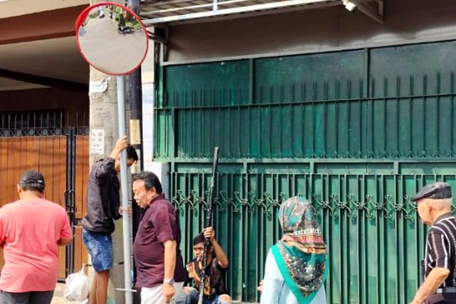 Proses pemasangan rambu lalu lintas lensa cembung dengan memperhatikan posisi dan sudut pandang pengguna jalan. (Humas Polinema)